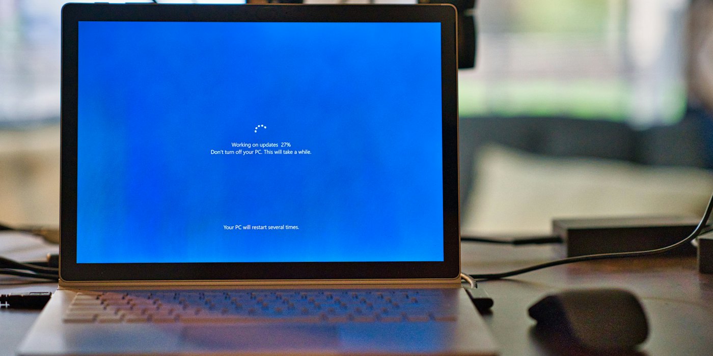 A laptop open on a desk, its screen glowing blue
