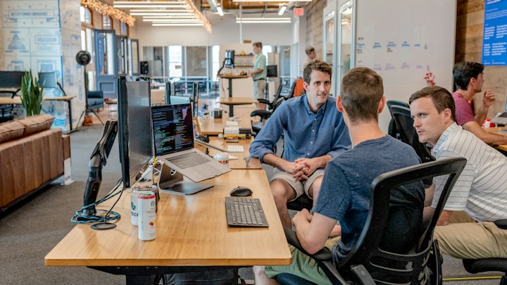 Engineers working together around laptops