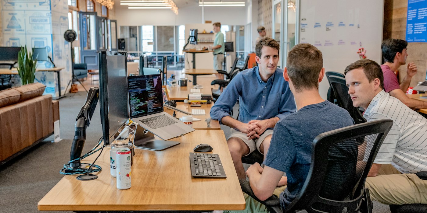 A team working together around laptops in an open office